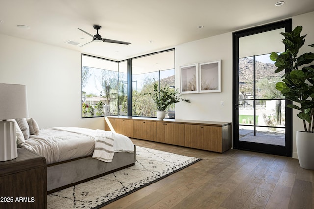 bedroom with hardwood / wood-style flooring, access to outside, visible vents, and ceiling fan