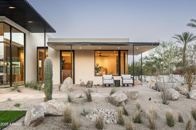 rear view of property featuring a patio area and stucco siding