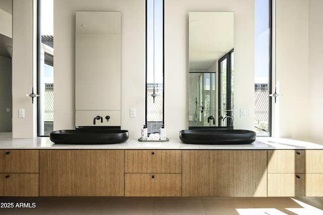 bathroom with double vanity, tile patterned flooring, and a sink