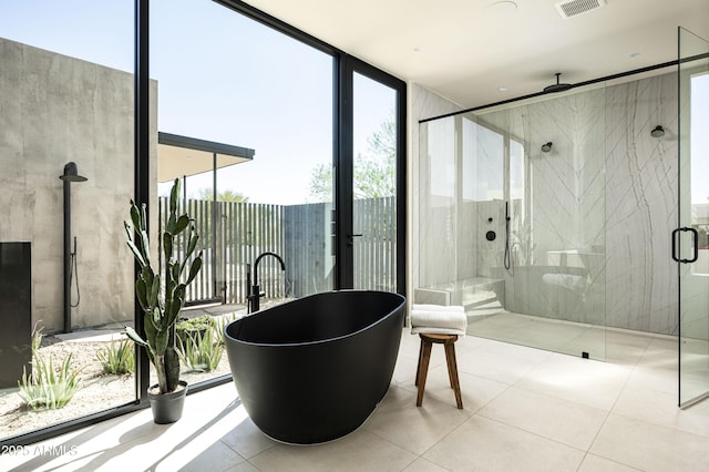 full bathroom with floor to ceiling windows, a soaking tub, visible vents, a stall shower, and tile patterned floors