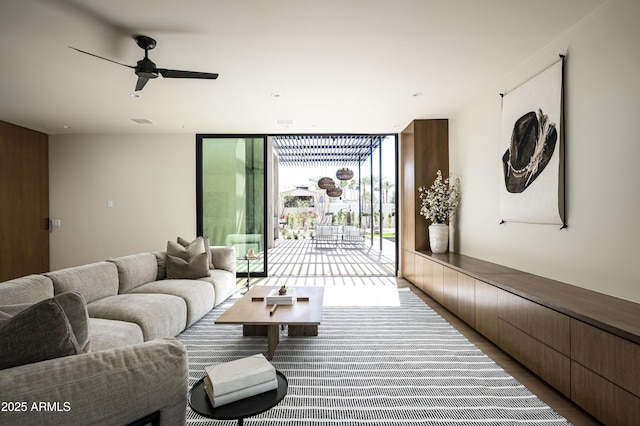 living area featuring ceiling fan, wood finished floors, visible vents, and floor to ceiling windows