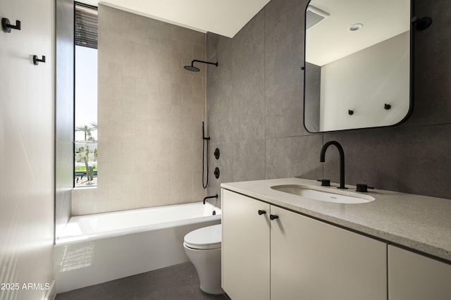 full bathroom featuring toilet, visible vents, vanity, tile walls, and  shower combination