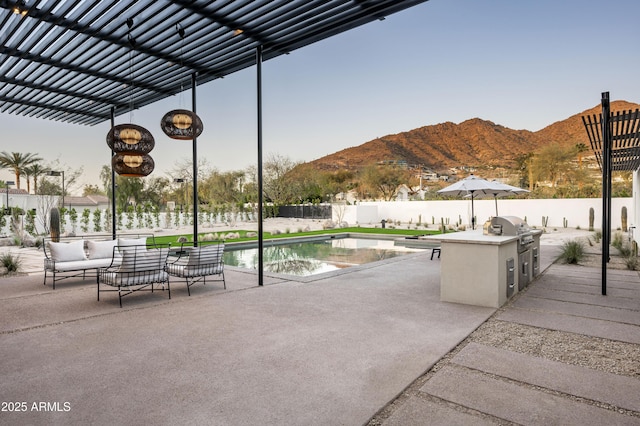 view of patio with an outdoor hangout area, area for grilling, a fenced backyard, and a mountain view