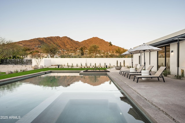 view of pool featuring a fenced backyard, a mountain view, a sink, a fenced in pool, and a patio area