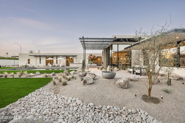 back of property with a yard, a pergola, and a patio
