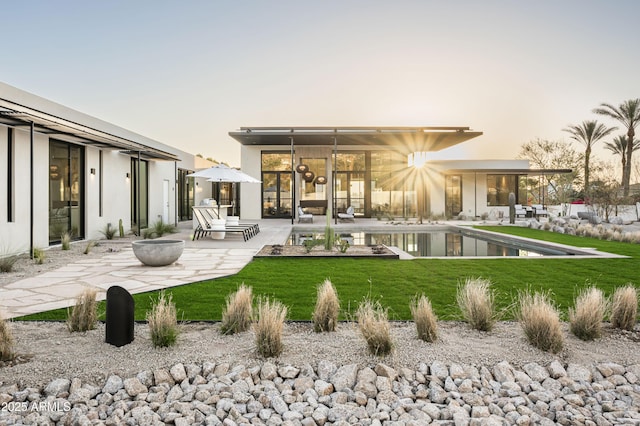 back of property featuring a yard, a fenced in pool, and a patio