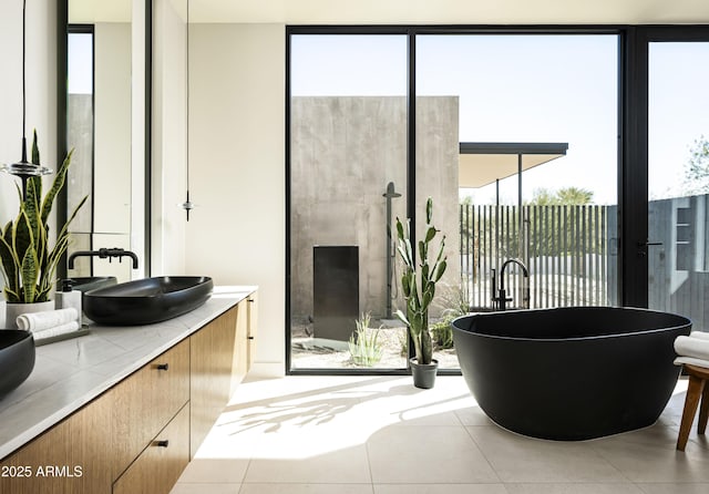 bathroom with a freestanding tub, vanity, a shower stall, tile patterned floors, and expansive windows