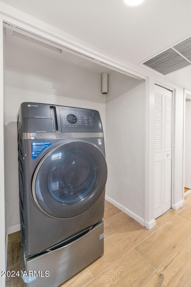 washroom featuring light wood-type flooring and washer / clothes dryer