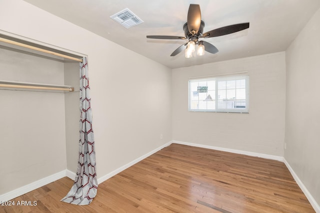 unfurnished bedroom featuring ceiling fan, wood-type flooring, and a closet