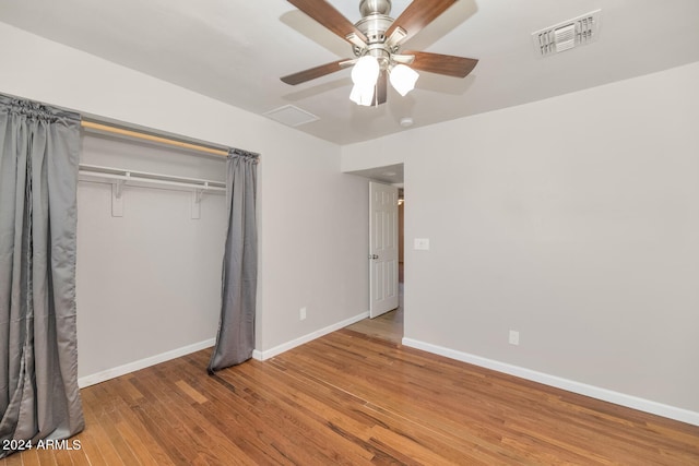 unfurnished bedroom featuring ceiling fan, a closet, and hardwood / wood-style flooring