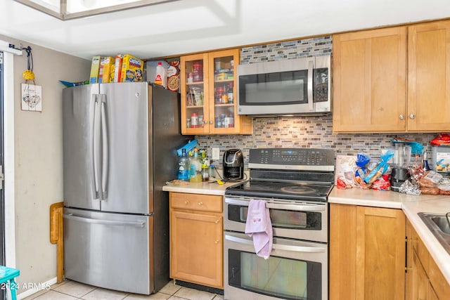 kitchen featuring light tile patterned floors, backsplash, and appliances with stainless steel finishes