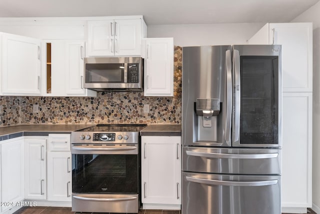 kitchen featuring white cabinets, stainless steel appliances, and tasteful backsplash