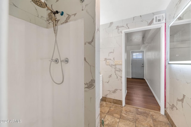 bathroom with a shower and wood-type flooring