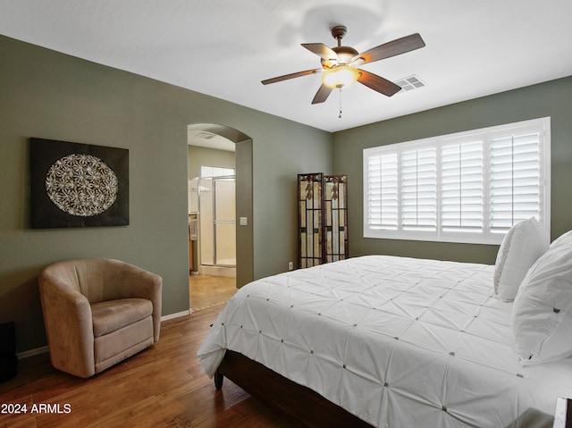 bedroom with ceiling fan, wood-type flooring, and ensuite bath