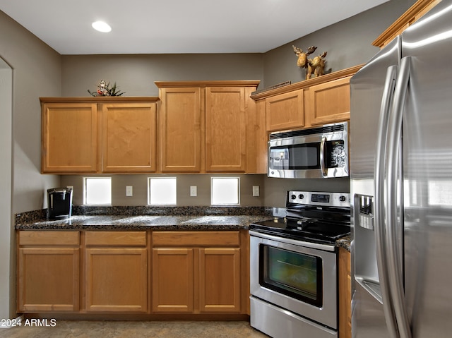 kitchen featuring dark stone countertops and appliances with stainless steel finishes