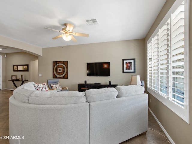 living room featuring ceiling fan and a healthy amount of sunlight