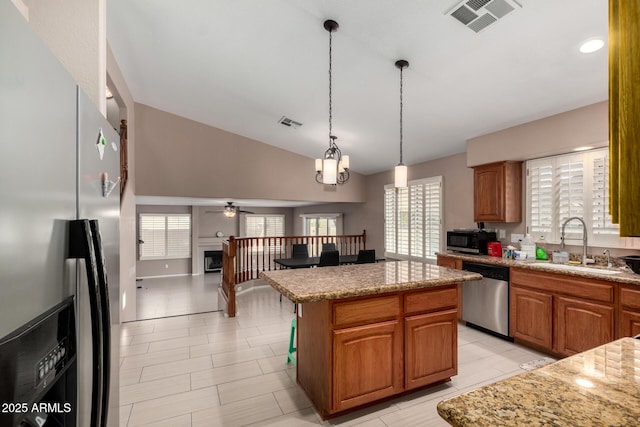 kitchen with a kitchen island, visible vents, vaulted ceiling, a sink, and stainless steel appliances