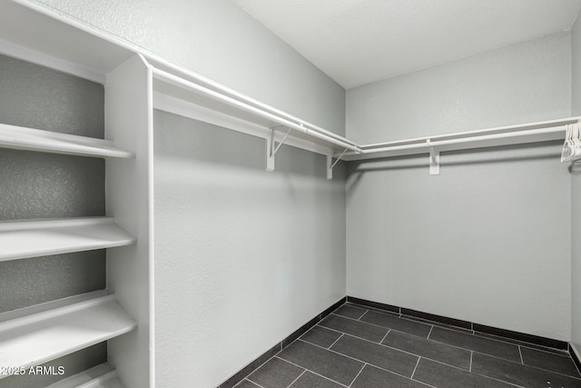 spacious closet featuring dark tile patterned floors