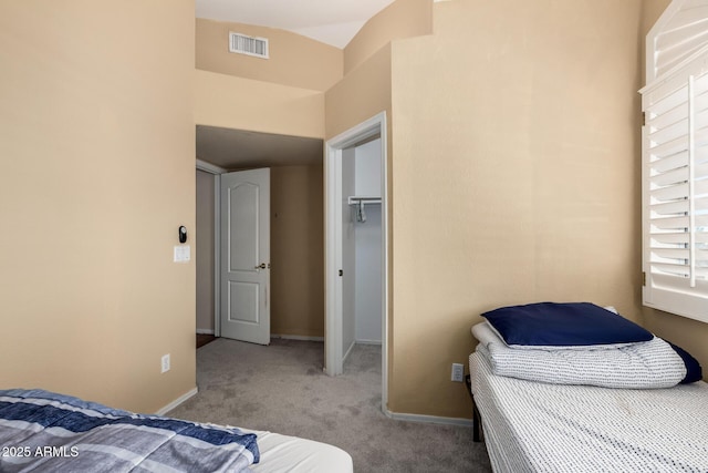 carpeted bedroom with a spacious closet, baseboards, a closet, and visible vents