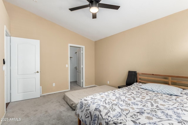 carpeted bedroom with baseboards, a ceiling fan, a walk in closet, and lofted ceiling