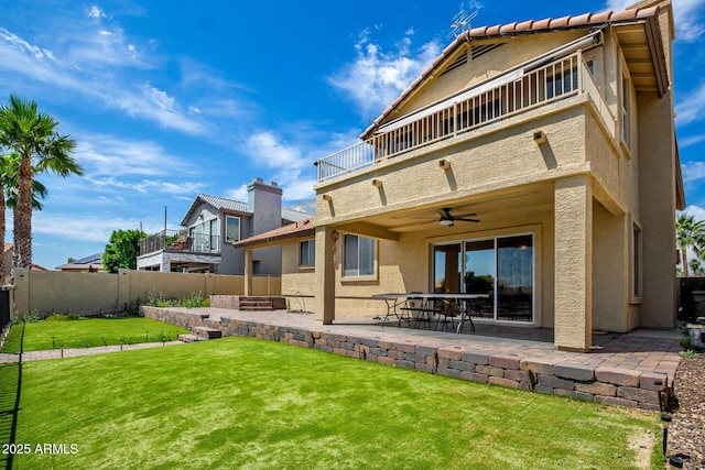 back of house with ceiling fan, a balcony, a patio, a fenced backyard, and stucco siding