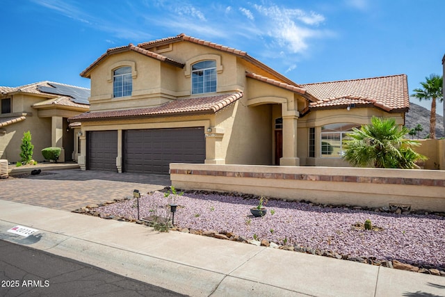 view of front of home featuring fence, an attached garage, stucco siding, a tiled roof, and driveway