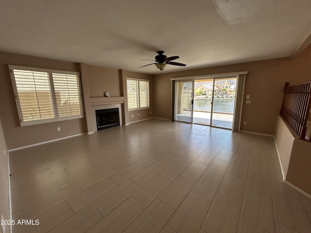 20713 N 56th Ave, Glendale, AZ 85308 - unfurnished living room featuring ceiling fan, baseboards, and a fireplace