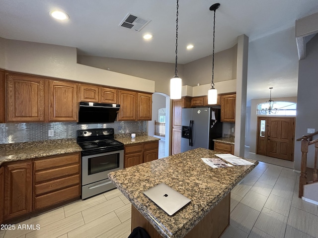 20713 N 56th Ave, Glendale, AZ 85308 - kitchen with appliances with stainless steel finishes, tasteful backsplash, brown cabinets, lofted ceiling, and arched walkways