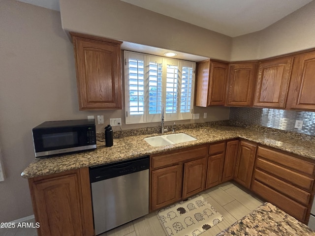 20713 N 56th Ave, Glendale, AZ 85308 - kitchen featuring dishwasher, a sink, brown cabinetry, and tasteful backsplash