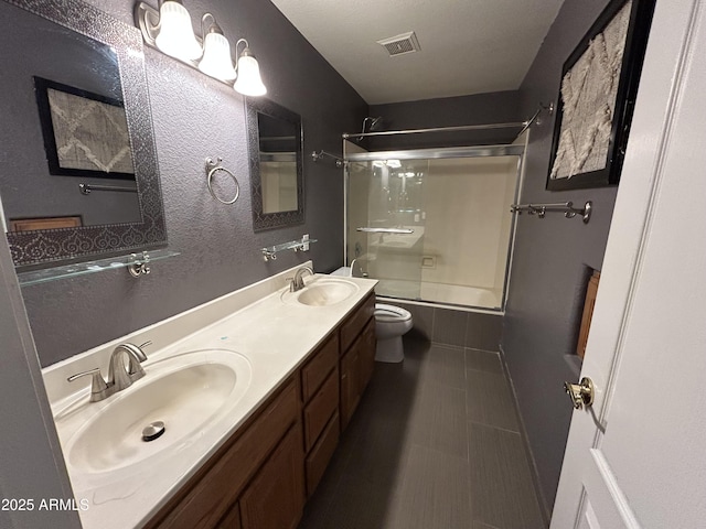 20713 N 56th Ave, Glendale, AZ 85308 - bathroom with combined bath / shower with glass door, toilet, double vanity, and tile patterned floors