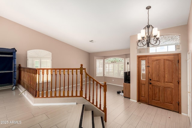 foyer entrance with an inviting chandelier, baseboards, and visible vents