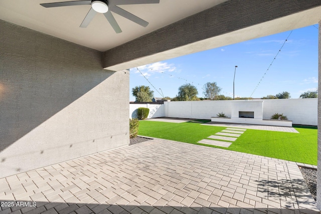 view of patio with ceiling fan and an outdoor fireplace