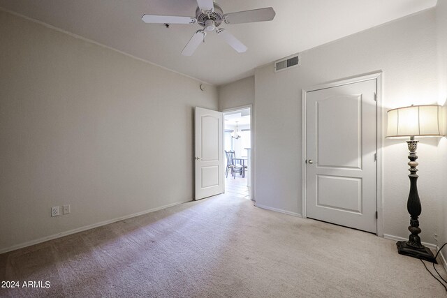 unfurnished bedroom with ceiling fan and light colored carpet