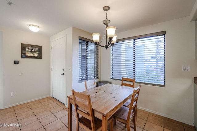 tiled dining room with an inviting chandelier