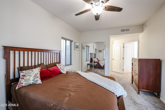 carpeted bedroom with ceiling fan and a closet