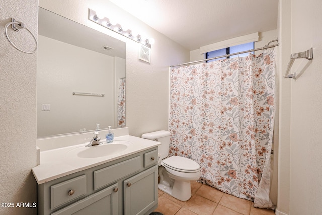 bathroom featuring toilet, vanity, and tile patterned flooring