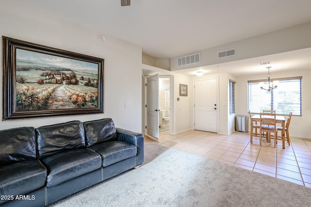 carpeted living room featuring an inviting chandelier