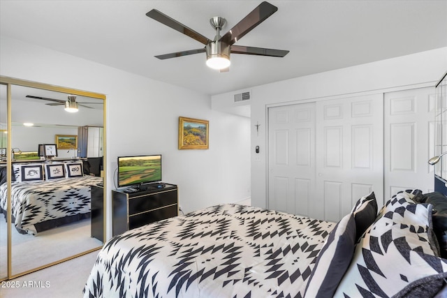 carpeted bedroom featuring visible vents, a closet, and ceiling fan