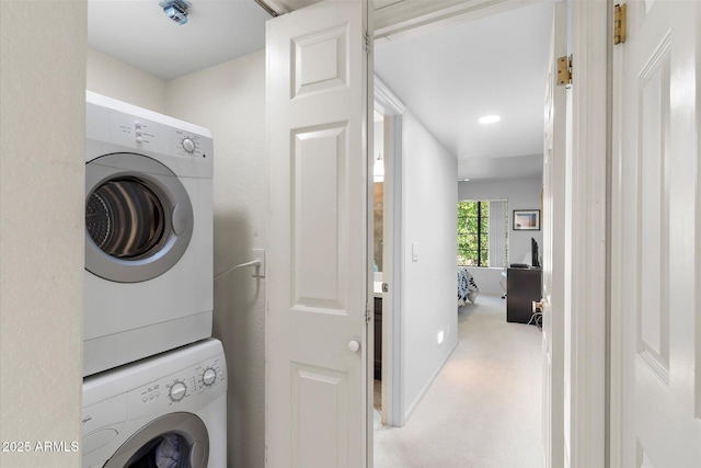 washroom with laundry area, stacked washer / drying machine, and carpet floors