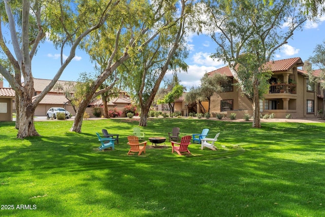 view of property's community with a fire pit and a yard