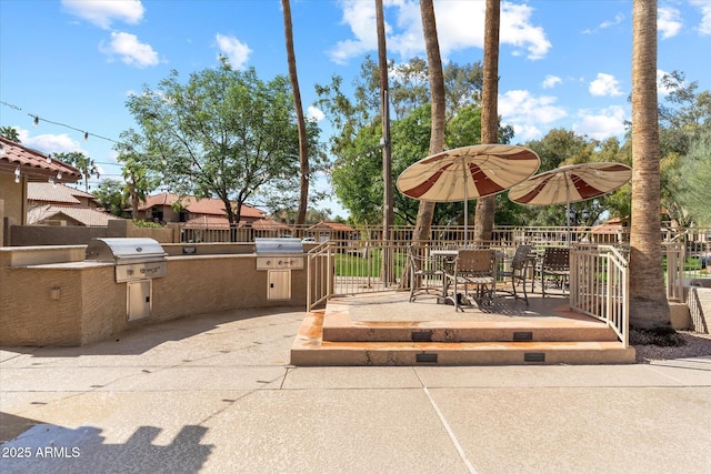 view of patio / terrace with area for grilling, a grill, and fence