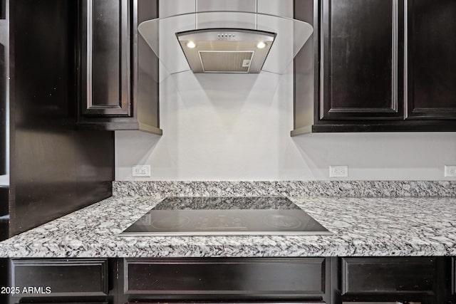 room details featuring range hood, black electric stovetop, and dark brown cabinets