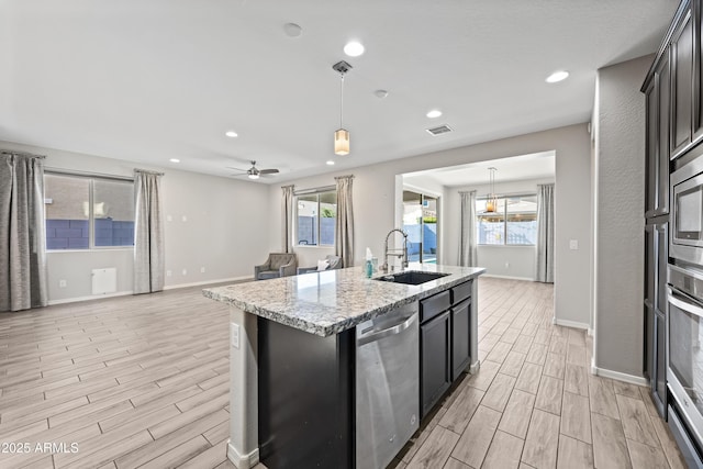 kitchen with stainless steel appliances, wood finish floors, visible vents, and a sink
