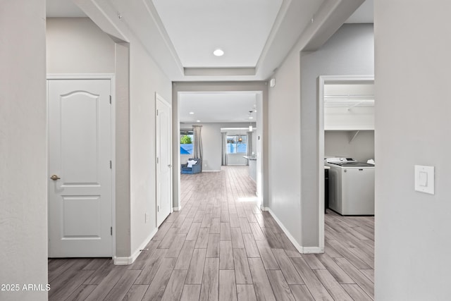 corridor with separate washer and dryer, baseboards, recessed lighting, and wood finished floors