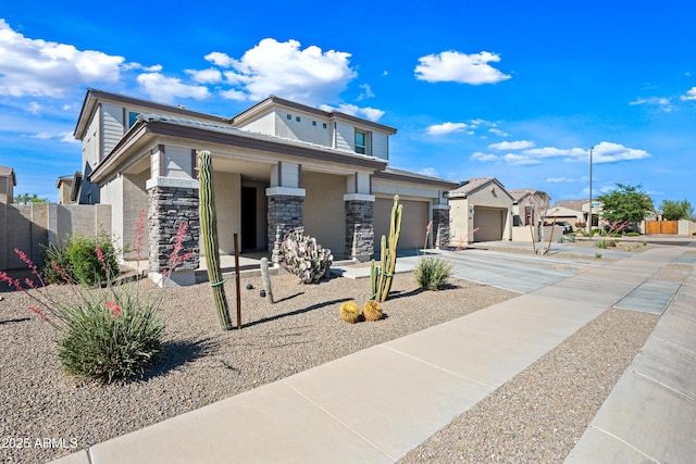 view of front facade featuring a garage, a residential view, driveway, and stone siding
