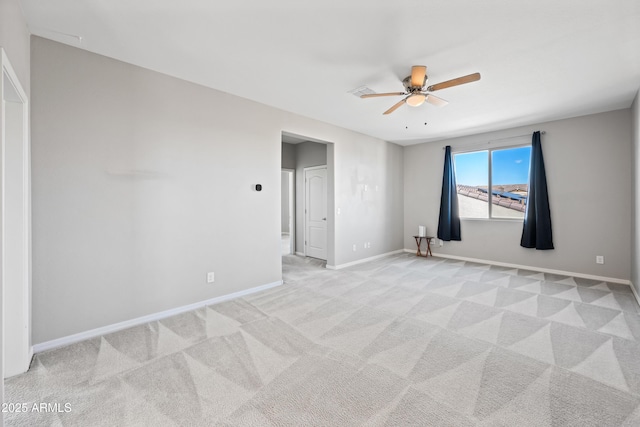 unfurnished room with ceiling fan, light carpet, and baseboards