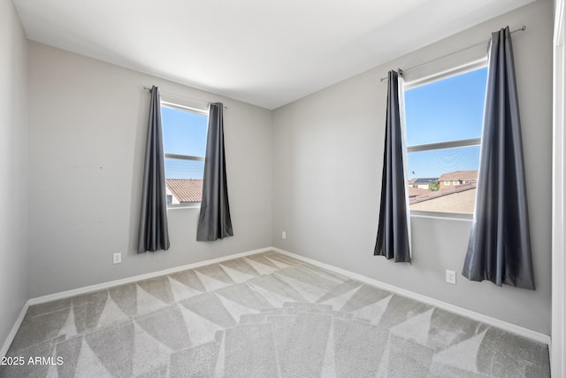 carpeted spare room with baseboards