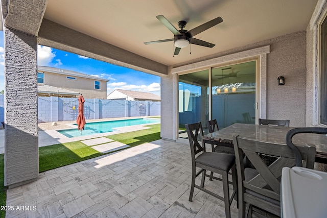 view of patio / terrace with a fenced in pool, a fenced backyard, ceiling fan, and outdoor dining area