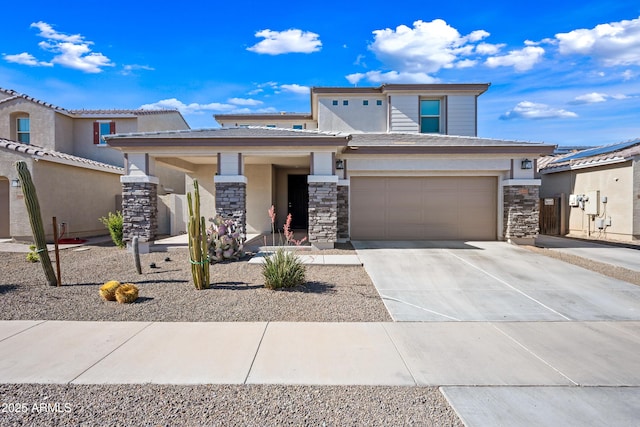 prairie-style house with a garage, concrete driveway, and stone siding