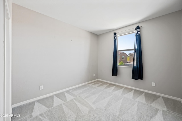spare room with baseboards and carpet floors
